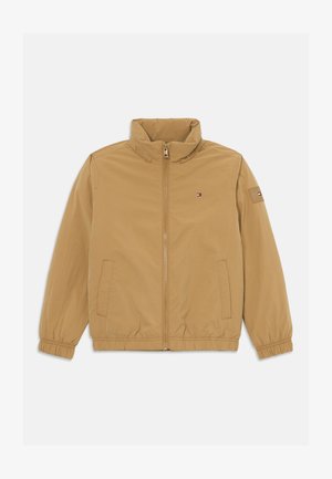 Svetlohnedá zipsová bunda so stojáčikom, elastickými manžetami a lemom, prednými vreckami a malým logom Tommy Hilfiger na hrudi a rukáve.