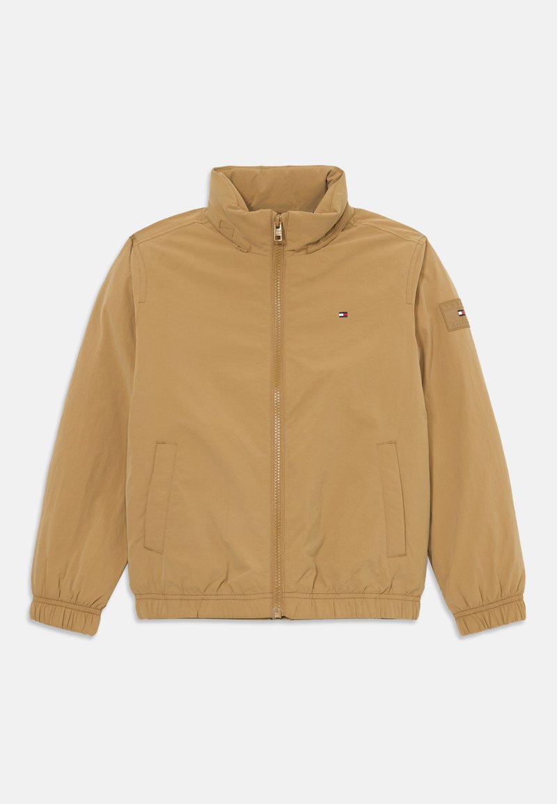 Lysbrun zip-up jakke med ståkrave, elastiske manchetter og kant, frontlommer og lille Tommy Hilfiger-logo på brystet og ærmet.