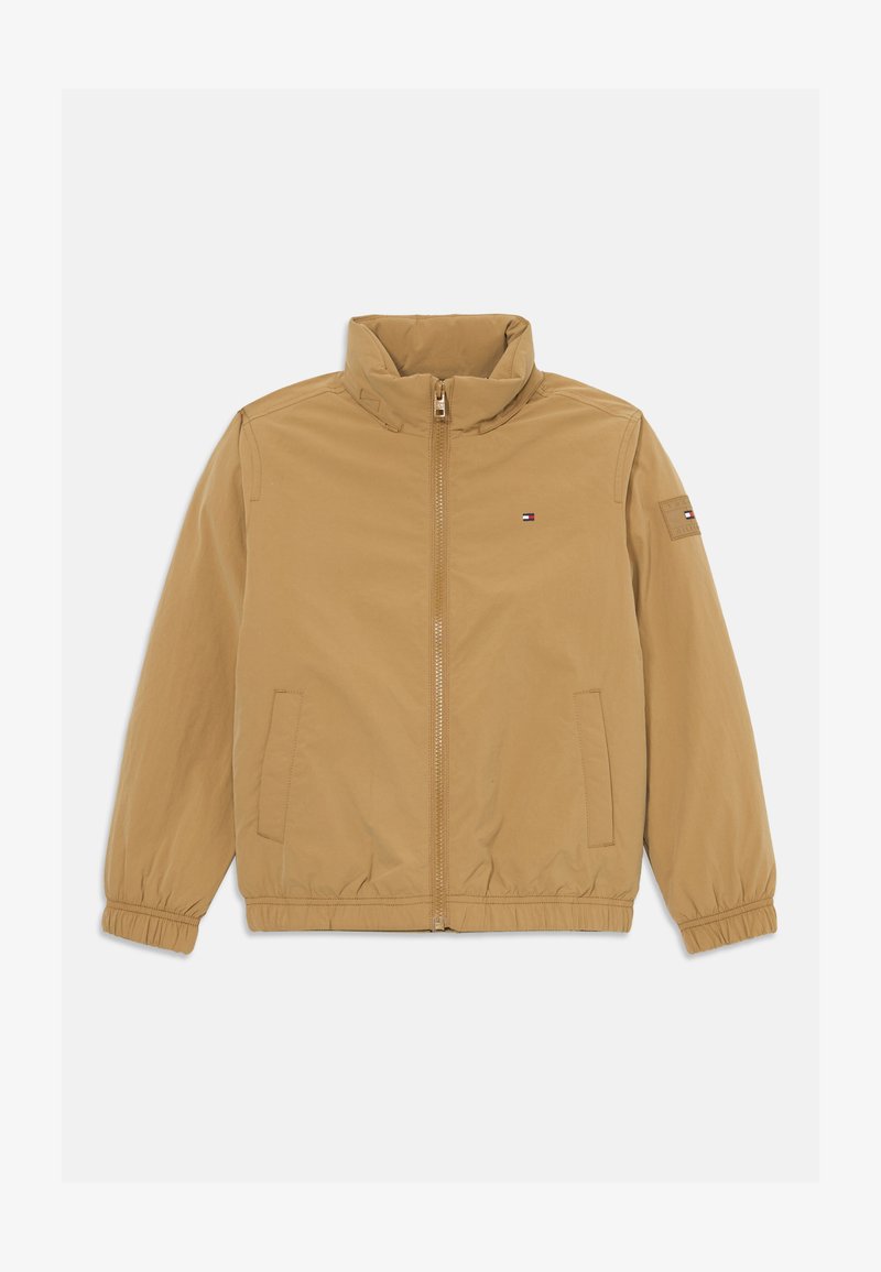 Lysbrun zip-up jakke med ståkrave, elastiske manchetter og kant, frontlommer og lille Tommy Hilfiger-logo på brystet og ærmet.