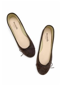 Bailarinas de ante marrón con punta redondeada y un lazo delgado. El forro es de color crema, con una plantilla acolchada y un borde elástico.