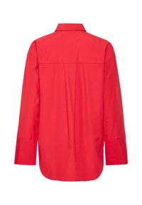 Camisa roja de botones con yugo en la parte posterior, mangas largas y un dobladillo ligeramente redondeado. Fabricada con una tela suave y sin patrones visibles.