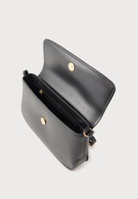 Geantă crossbody din piele neagră cu accesorii aurii, având un compartiment principal și un buzunar interior cu fermoar. Textură netedă și design structurat.