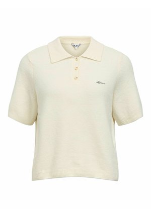 Polo crème à manches courtes, en tissu tricoté texturé, avec trois boutons et une petite broderie de logo sur le côté gauche.