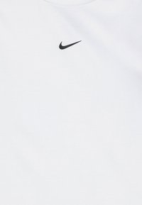 Hvit T-skjorte laget av bomull med en liten svart Nike swoosh-logo på øvre brystområde. Enkelt design og rund hals.