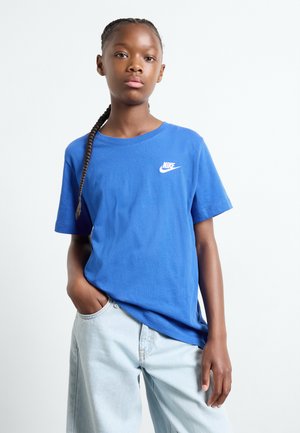 Modrá bavlnená tričko s krátkymi rukávmi, s malým bielym logom Nike na hrudi. Kombinované s svetlými džínami.