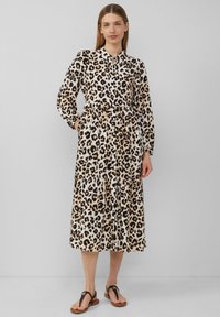 Luipaardprint jurk met een knoopsluiting aan de voorkant, lange mouwen en een gelaagde rok. Gemaakt van soepele stof met een relaxte pasvorm. Voorzien van zakken.