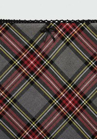 Tissu gris avec un motif à carreaux rouge, noir, blanc et jaune, bordure en dentelle noire et un petit nœud noir près du bord supérieur.
