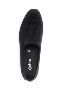 Black slip-on shoe with a textured mesh upper, round toe, and a soft sole. Featuring a padded insole with circular perforations. Brand logo visible.