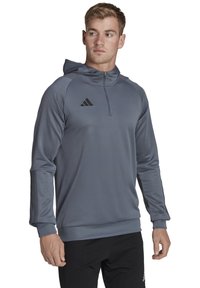 Felpa grigia a maniche lunghe con mezza zip. Presenta dettagli neri e logo, tessuto testurizzato e design aderente. Polsini e orlo a costine.