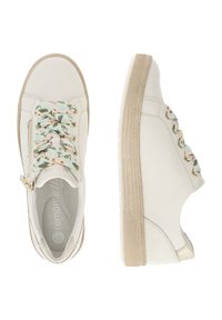 Baskets en cuir blanc avec un motif de dentelle florale, fermeture éclair sur le côté et semelle beige clair. Présente une texture lisse et des coutures accentuées.