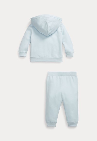 Hellblauer Kapuzenpullover für Kleinkinder und passende Hose mit elastischem Bund, flach auf weißem Hintergrund ausgelegt.