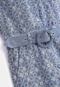 Jeansowa sukienka z białą kwiatową haftowaną ozdobą. Posiada dopasowany pasek z okrągłą klamrą oraz zapięcia na guziki w jasnoniebieskim kolorze.