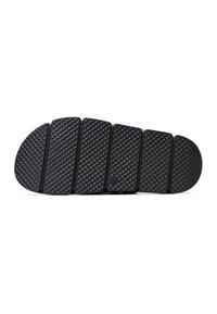 Semelle de chaussure noire segmentée avec motif diamant texturé sur chaque section, conçue pour la flexibilité et l'adhérence, présentée sur fond blanc.