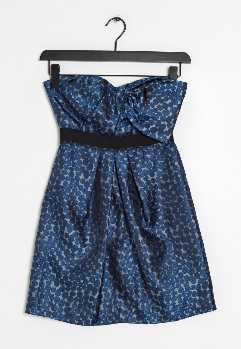 Olkaimeton tummansininen satiinimekko, jossa on hunajakennokuvio. Mekossa on solmittu yksityiskohta ylhäällä ja musta vyötäröosa.