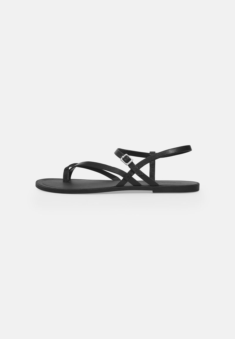 Black sandals with flat soles featuring multiple thin straps and a buckle detail. Smooth texture with a minimalist design.