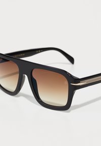 Ochelari de soare negri, rectangulari, cu lentile maro cu gradient, având un cadru elegant negru și temple accentuate cu aur. Finisaj texturat pe brațe.