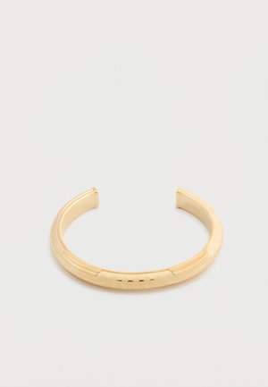 Bracciale aperto in tono oro con sottili motivi incisi, esposto su uno sfondo bianco.