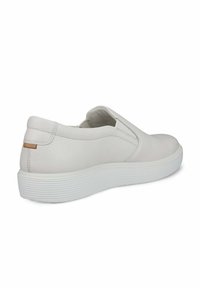 Scarpa bianca in pelle senza lacci con finitura testurizzata, dotata di suola in gomma bianca e sottile accento nocciola sul tallone. Design elegante.
