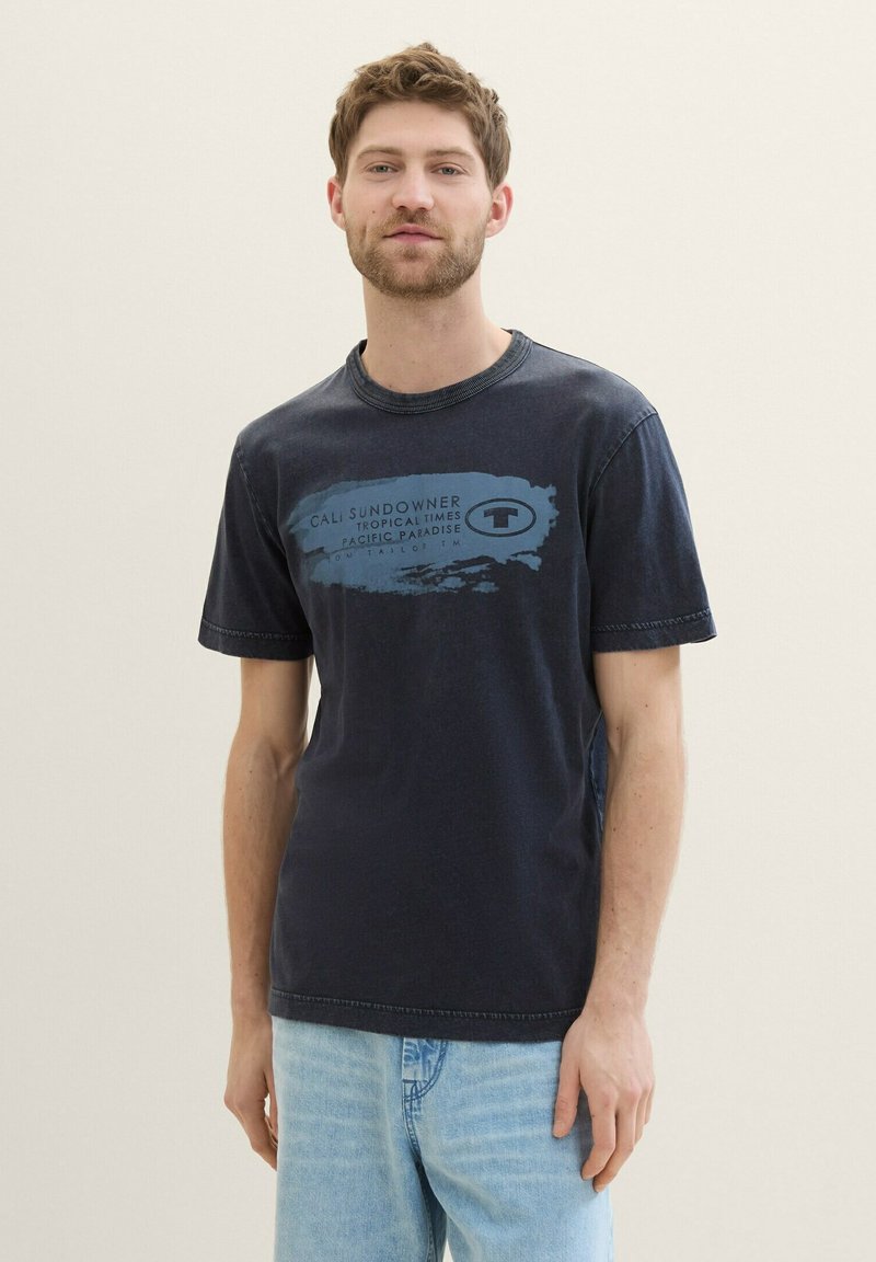 Mørkeblå bomulds t-shirt med rund hals og korte ærmer, prydet med et grafisk print i lyseblå tekst og abstrakt design på forsiden.