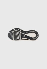 Black rubber sneaker outsole with a textured grip pattern. White midsole with a sleek, curved design and prominent tread lines.