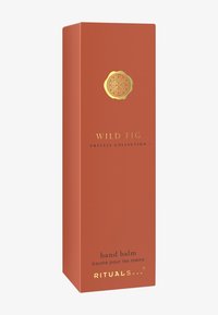 Rektangulär, strukturerad orange förpackning för handbalsam med gulddetaljer och präglad logotyp; märkt "Wild Fig, Private Collection."