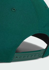 Zielona czapka z fakturowanej tkaniny, wyposażona w zaokrąglony daszek, regulowany plastikowy pasek oraz subtelne detale przeszyć.