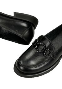 Czarne loafersy ze skóry z fakturowanym detalem łańcucha na cholewce, zaokrąglonym noskiem i rowkowaną gumową podeszwą, widoczne z góry i z boku.