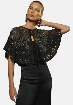 Black sheer cape with intricate silver bead and stitch embellishments, featuring a tie closure and fluttering sleeves.