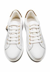 Witte leren sneakers met gouden metalen oogjes, platte veters, gestructureerde bruine accenten bij de hiel en een licht gebogen rubberen zool.