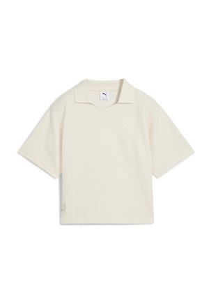 Polo à manches courtes couleur crème texturé avec un petit logo Puma sur la poitrine et un col.