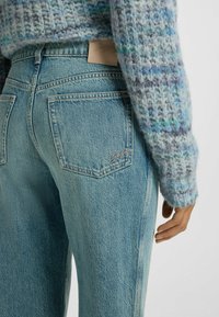 Ljusblå, högmidjade jeans med rak bendesign, som har en läderlogotyp på bakfickan och en broderad logotyp.