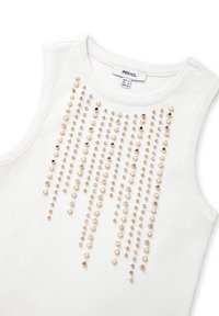 Top sin mangas blanco de canalé con un diseño vertical de adornos de oro, perlas y cristales en la parte frontal. Etiqueta visible en el escote.