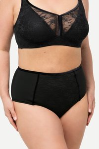 Bralette noir en dentelle avec un panneau transparent et un slip noir taille haute. Présente une texture florale et des ceintures élastiques lisses.