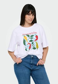 Camiseta blanca de algodón con un diseño gráfico colorido de pimientos y hojas con el texto "PIMENTÓN". Mangas cortas y corte relajado.