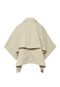 Veste courte beige de style cape avec manches larges, empiècement au dos et ourlet asymétrique.