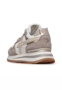 Sneaker beige e bianco con dettagli in camoscio, pelle e metallici. Presenta una suola texturizzata e un logo discreto sul retro.
