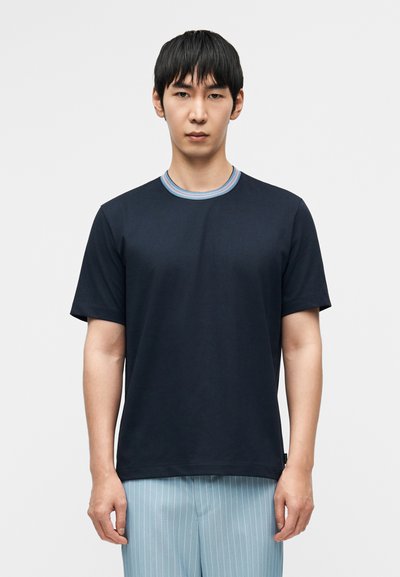 Σκούρο μπλε κοντομάνικο μπλουζάκι με ριμπ λαιμόκοψη που έχει ανοιχτό μπλε και κόκκινες λεπτομέρειες. Με ομαλή υφή και άνετη εφαρμογή.