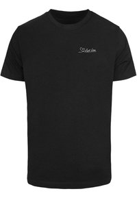 Zwarte katoenen t-shirt met korte mouwen, een ronde hals en een witte "Just Love" tekstontwerp aan de bovenste linkerkant. Gladde textuur.