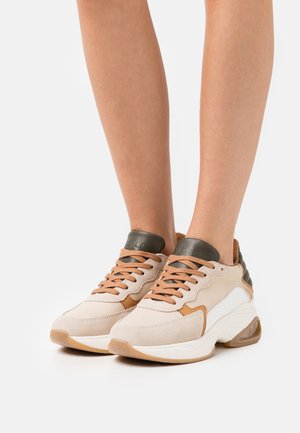 Sneaker in suede e pelle beige con accenti marroni, imbottitura testurizzata alla caviglia e lacci marroni. Suola spessa bianca con tacco trasparente.