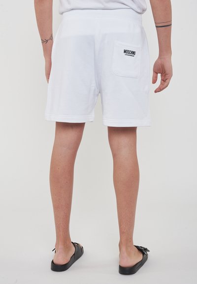 Shorts bianchi in cotone con vestibilità rilassata, caratterizzati da un logo "Moschino" ricamato sulla tasca posteriore e una consistenza liscia.