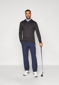 Crna dukserica s kapuljačom, mornarske hlače, bijele sportske tenisice. Nose košulju s ovratnikom, drže golf štap. Jednostavan dizajn i značajke.