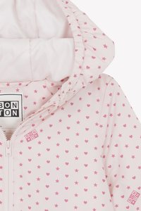 Light pink jacket with an all-over pattern of small stars and hearts, featuring a zip closure and a gathered hood. Brand label visible.