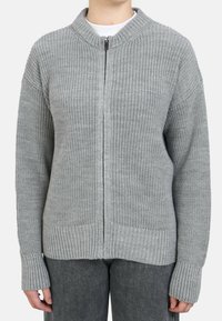 Cardigan gris de punto con cierre de cremallera en la parte frontal, puños y dobladillo acanalados. Presenta un patrón texturizado y dos grandes bolsillos frontales.