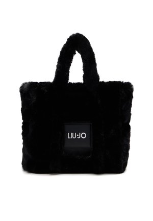 Bolso tote de piel sintética negra con doble asa corta, forma rectangular y un parche con el logo en un panel negro liso.