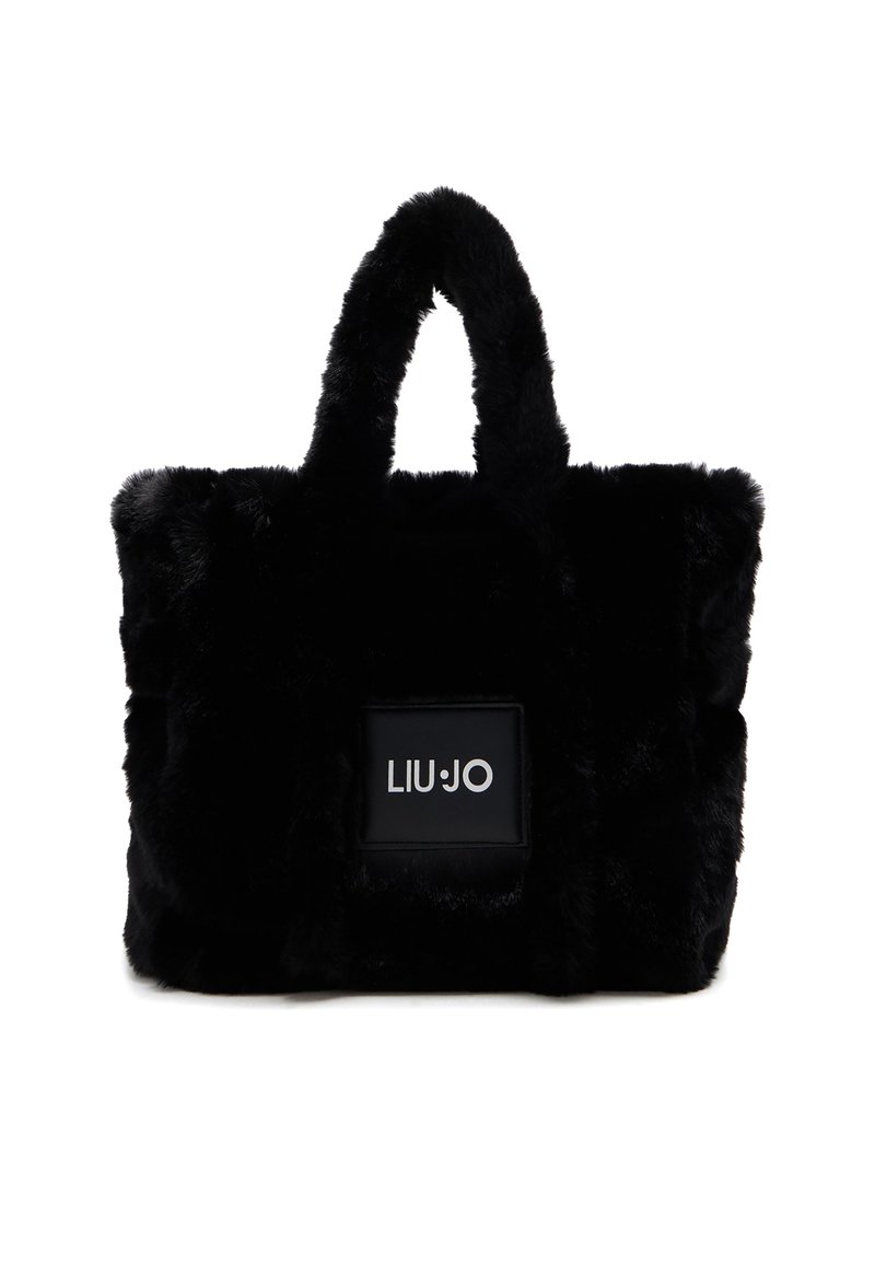 Borsa a spalla in pelliccia sintetica nera con doppio manico corto, forma rettangolare e una toppa con logo su un pannello nero liscio.