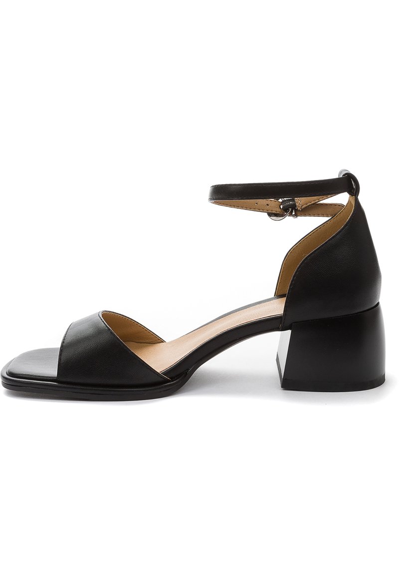 Black leather ankle strap sandal with a square open toe, low block heel, sleek design, and subtle interior detailing.