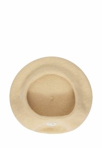 Sombrero de fieltro beige con ala ancha y una textura suave. La circunferencia interior presenta un acabado liso, con un sutil logo en blanco.