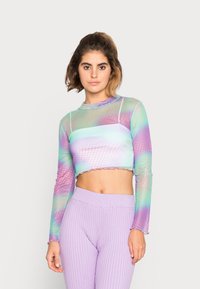 Top cropped em malha leve com um gradiente de cores pastel, padrão de bolinhas e bainha recortada. Combinado com leggings de lavanda caneladas.