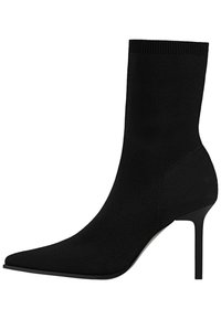 Bottine noire en tricot avec un bout pointu et un talon stiletto fin. Texture lisse avec un design sans coutures et une tige ajustée.