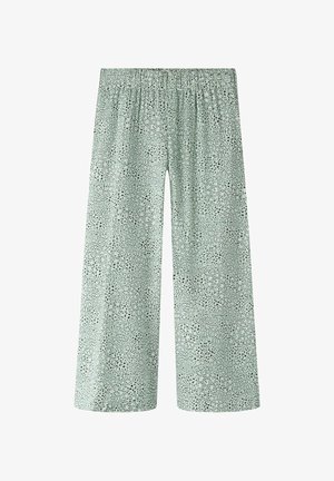 Heledad rohelised laiad püksid mustade ebaühtlaste täppidega ja elastse vöökohaga, lai säärekärje lõige, esikülje vaade valgel taustal.